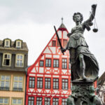 The Fountain Of Justice located in the Roemerberg, Frankfurt, Germany. Half-timbered buildings on the background